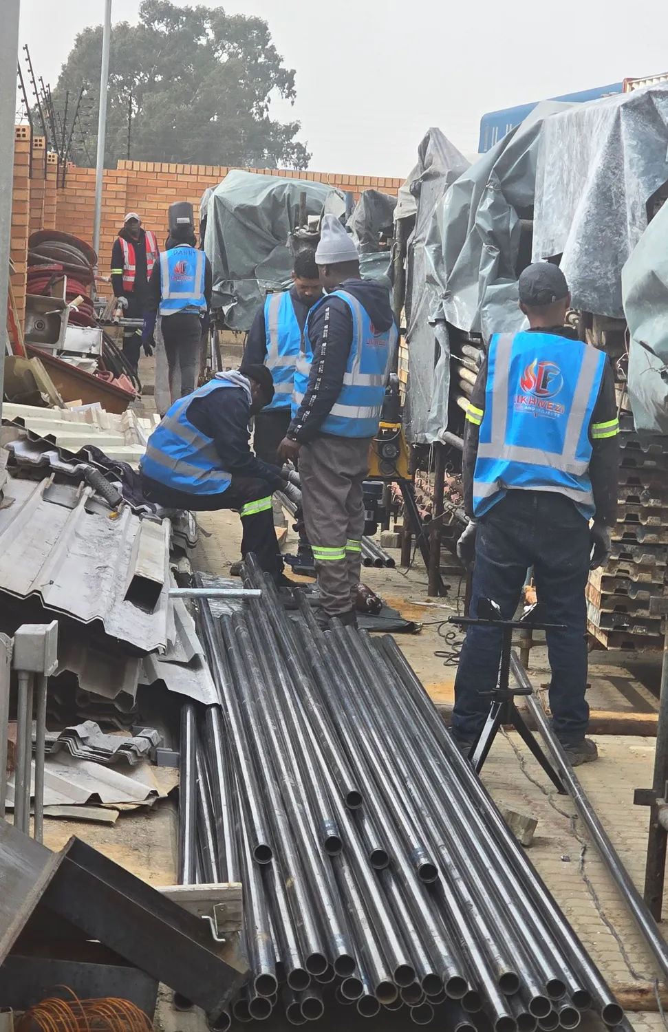 Likhwezi team preparing steel piping on a construction project